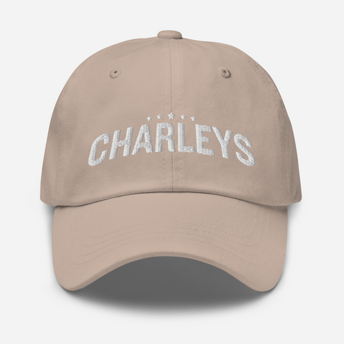 Classic dad hat with light tan fabric and white thread that says 